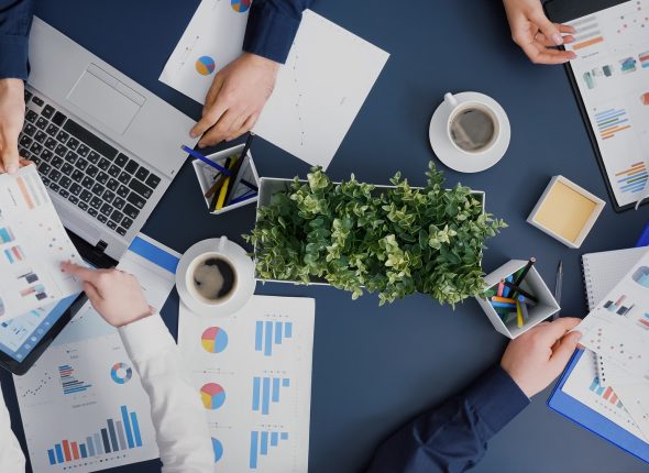 top-view-business-group-analyzing-company-infographics-documents